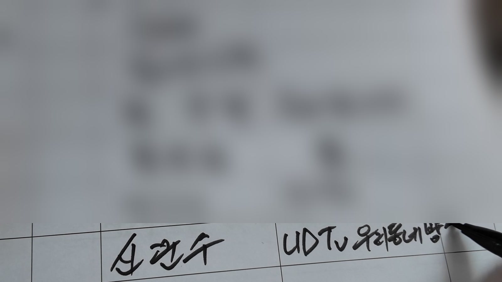 방명록 맨 아래 칸에 펜으로 ‘신문수 UDTv 우리동네방…’이라고 적는 모습. 위쪽 다른 이름들은 흐리게 가렸다